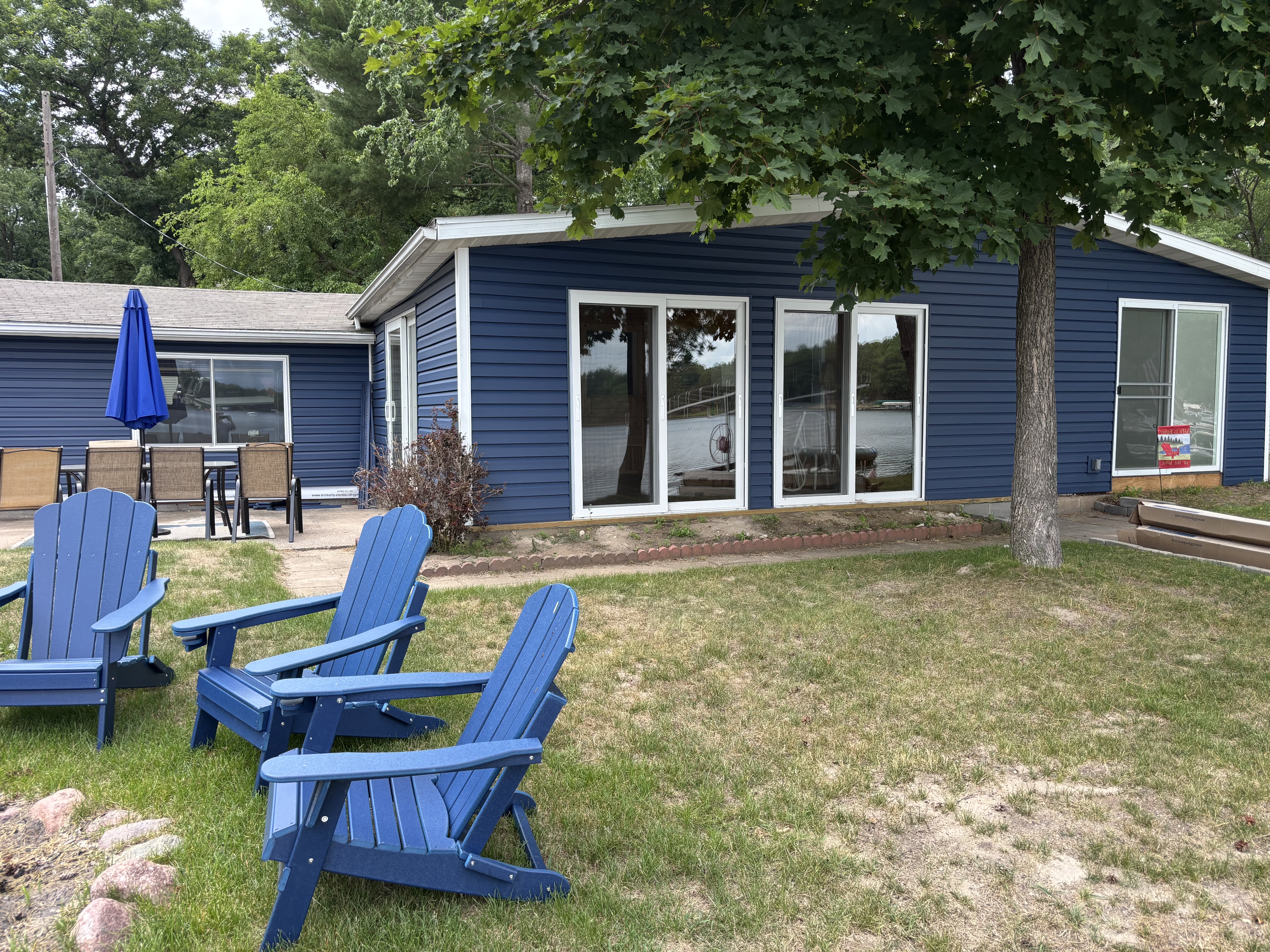 Pine Lake Escape blue siding patio and lake view